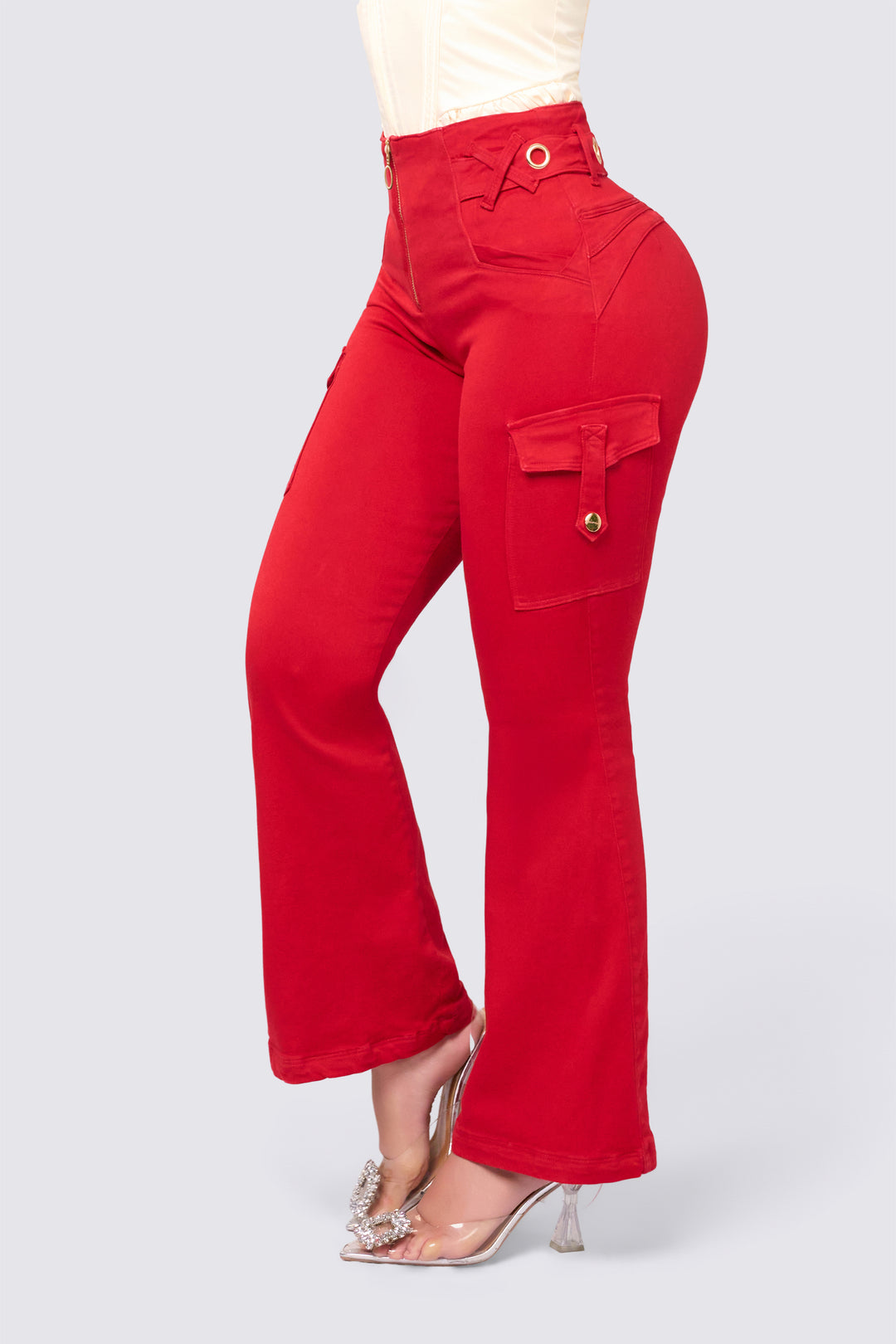 Pantalón bota campana color rojo, de tiro alto, con cierre frontal, y detalles metálicos en la pretina. 