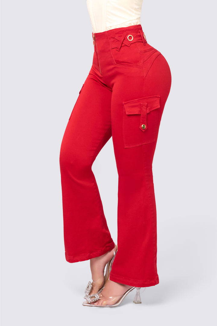 Pantalón bota campana color rojo, de tiro alto, con cierre frontal, y detalles metálicos en la pretina. 