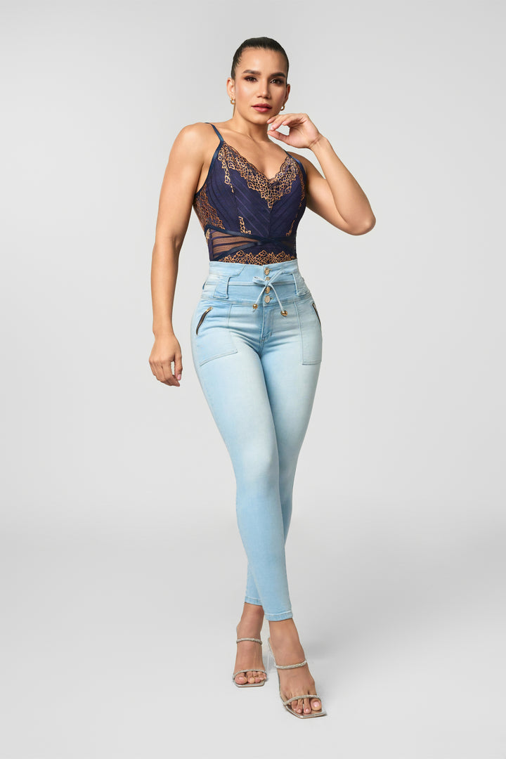 Skinny jeans color azul claro, tiro alto alto, con botones delanteros, y correa ajustable en denim. 
