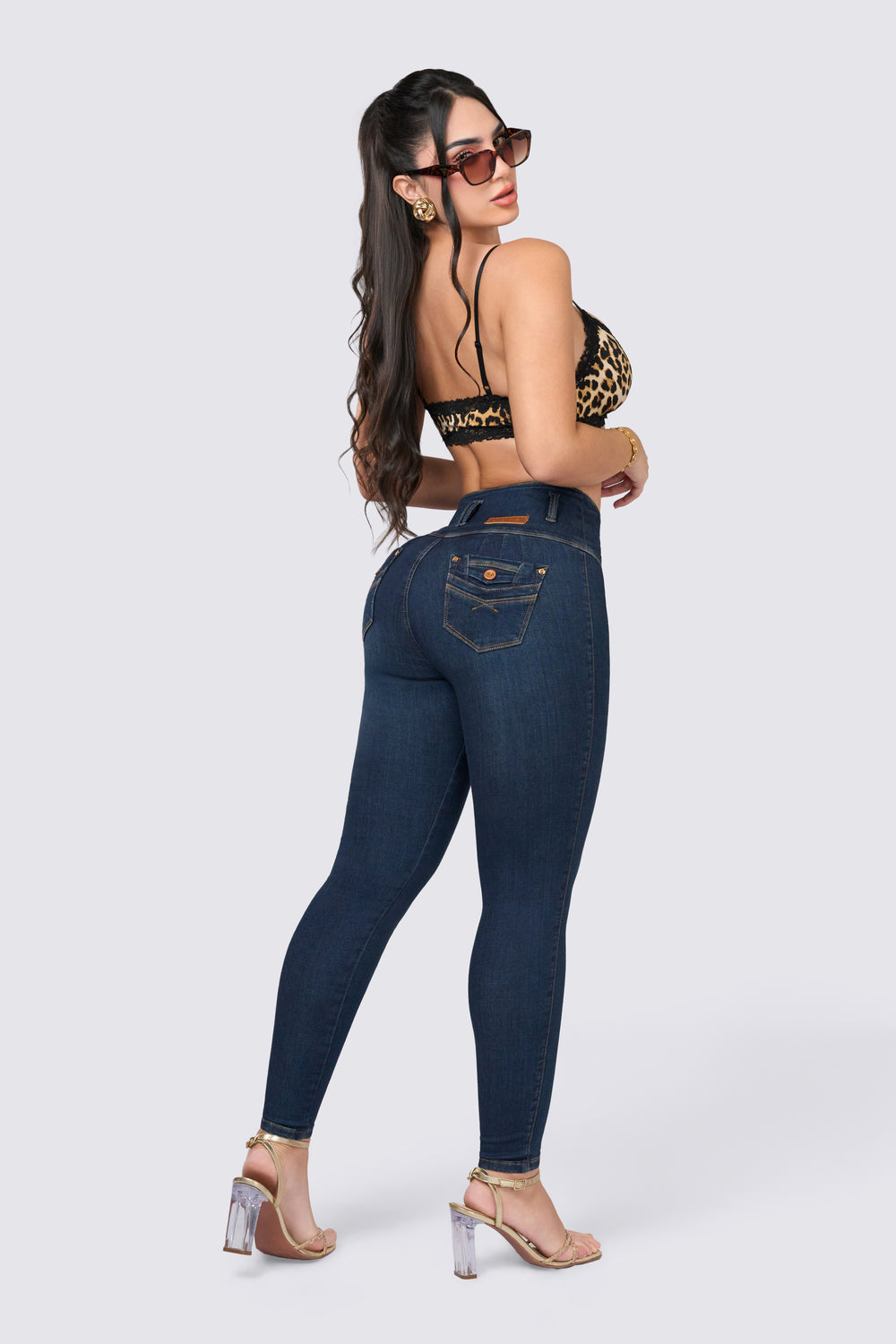 Skinny jeans de azul oscuro, de pretina ancha, botones laterales y bolsillos traseros.