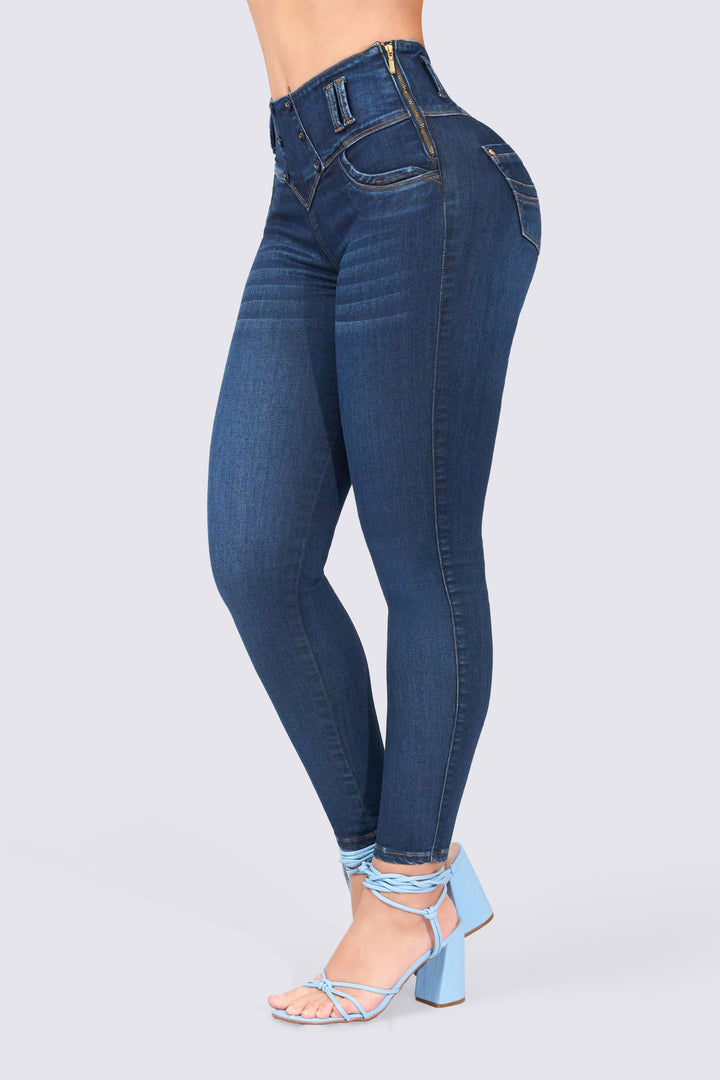 Skinny jean azul oscuro, ajustado de cintura a tobillos, con cierre lateral y bolsillos traseros. 