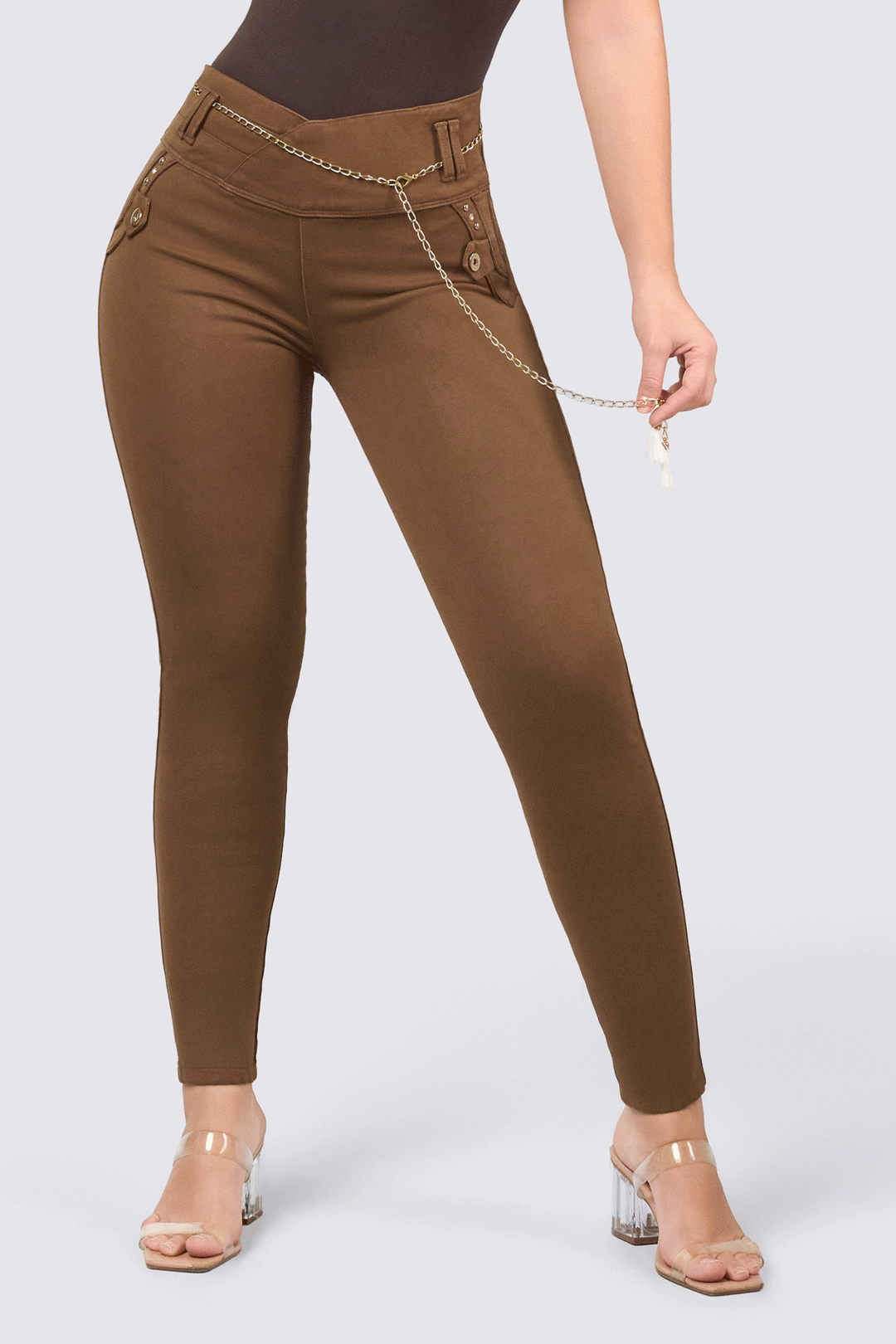 Skinny jeans color café oscuro, con pretina tiro medio, incluye cadena decorativo y un efecto que realza tus curvas. 
